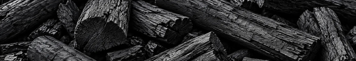 Gros morceaux allongés de charbon de bois noir en gros plan